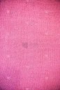 粉色腮红紫色洋红针织图案羊毛衫纹理接近。手工制作的粉红、紫色、品红织毛织背景
