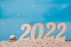 有创意的圣诞贺卡。2022年的新年，在海边的沙滩上堆起一个石堆。有选择性的重点。副本的空间。
