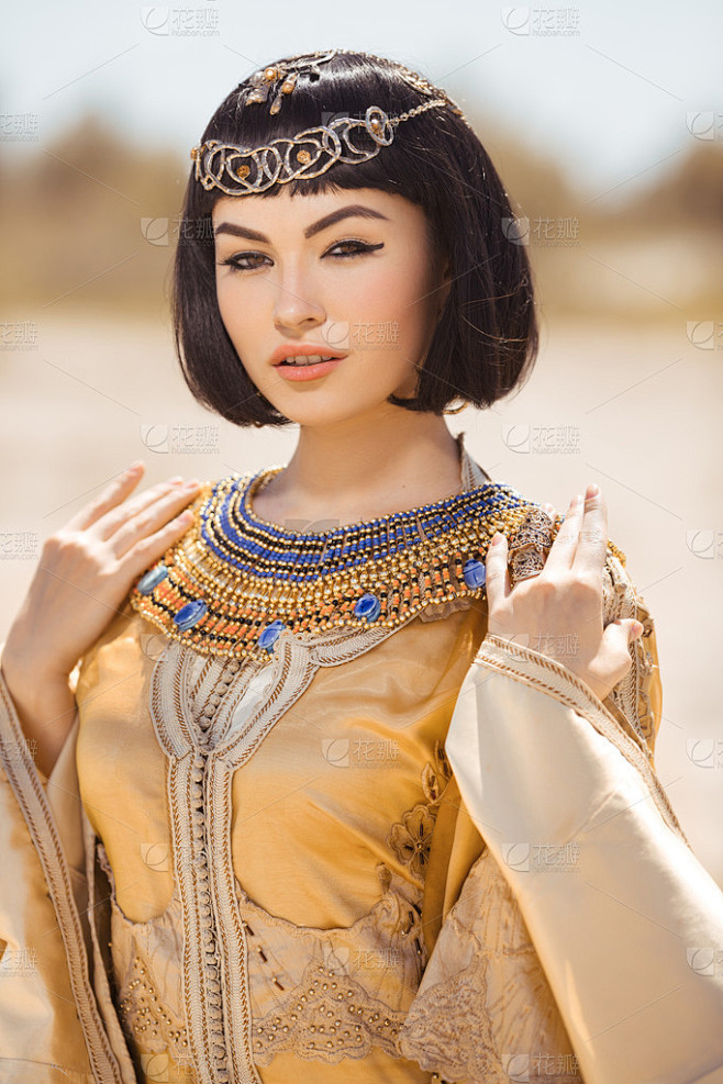 美丽的女人与时尚化妆和发型像埃及女王克娄巴特拉在户外对沙漠