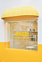 This may contain: a yellow awning on the side of a store front window with an advertisement for dazzi coffee and dessert