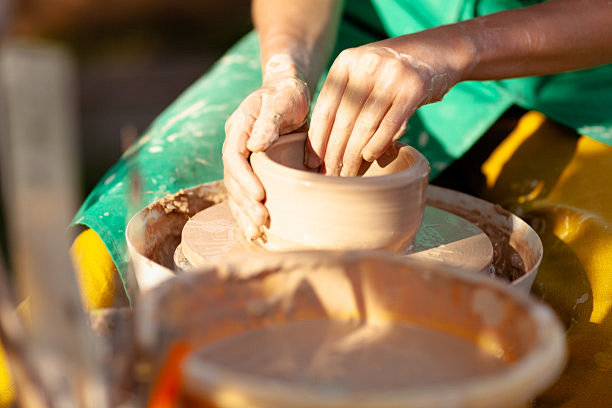 在车轮上制作陶器的手工工艺。女性手用陶土...