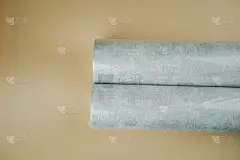 用于装饰墙壁和修理的墙纸被卷绕成塑料包装，背景为橙色