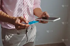 男人拿着手机与支付详情页面显示和信用卡，网上购物的概念