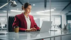 成功的白人女商人在完美时尚的西装在笔记本电脑在顶楼办公室俯瞰大城市。管理环境、社会和公司治理的女性首席执行官图片下载