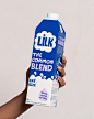 This may contain: a person holding up a carton of milk