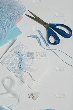 制作贺卡。白色桌面上的工艺品配件。干花和工艺品缎带。创造力的工具。