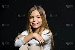 可爱的过载。女孩长发可爱笑脸放松，黑色背景。这个女孩的微笑很可爱。善待他人。孩子的快乐充满你的正能量