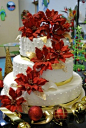 Three tier white, red and gold Christmas wedding cake, decorated with cascading red Christmas flowers and red and gold Christmas decoration balls. From Key Limes Yummies Bakery www.flickr.com  #wedding #cake www.BlueRainbowDesign.com