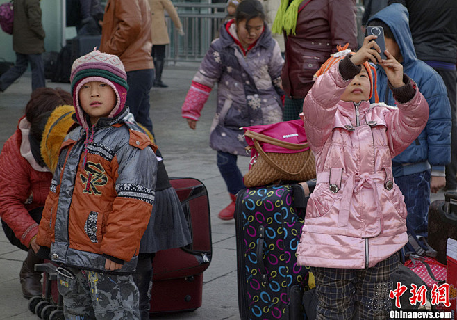 1月21日，两名儿童和家人一同北京西客站...