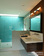 卫浴间看似简单、整洁，实则在设计上精致到了每一个细节。宽敞的淋浴间，最里侧的墙壁是用色最深最抢眼的碧蓝色。轻松为卫浴间渲染出蓝色基调。地面以及隔断，用淡蓝色圆形马赛克铺设，及其精美。卫浴柜选择了挂壁式，进一步塑造宽敞、清爽与整洁。