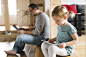 Father with laptop and little daughter with tablet at home.