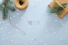 圣诞组成。圣诞框架由冷杉树枝，礼盒，绳子，彩色星星在柔和的蓝色背景。平铺，俯视图，拷贝空间。圣诞节、