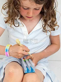 孩子在织布机上做手镯