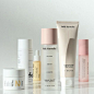 several different types of skin care products lined up on a white counter top with reflections