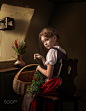 Young girl weaves a wreath at the window