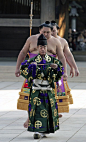 Goji (referee) leading sumo wrestlers