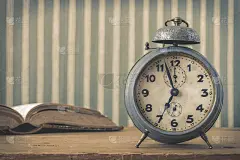 一个旧闹钟和一本打开的书