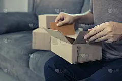 亚洲企业家少年正在打开一个纸箱，为了把客户订购的产品放进盒子里，以交付产品。