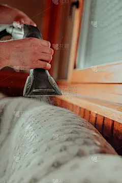 贴身管家手持现代吸尘器，用专业清洁剂清洗脏沙发。专业的家居春季大扫除概念