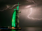 迪拜，自然与人造的光线在夜空下相互辉映。闪电为波斯湾旁的帆船形状的，高达321米的绿色的阿拉伯塔酒店增加了点缀。
摄影：Maxim Shatrov