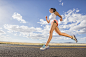 Photograph Low angle view of Caucasian woman running on remote road by Gable Denims on 500px