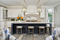 Beach style l-shaped open plan kitchen in Grand Rapids with white cabinets, quartz benchtops, beige splashback, subway tile splashback, stainless steel appliances, light hardwood floors, with island, grey floor, white benchtop, coffered and flat-panel cab