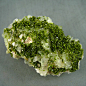 绿帘石水晶共生 桂林矿物奇石交易网。碧绿清澄的绿帘石，生长在晶莹剔透的水晶上，格外显得生机盎然、蓬勃向上，同时绿帘石又是很好的矿物标本，深受矿物收藏家的喜爱。