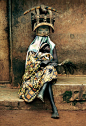 Africa | "Baba Ichanga" wearing traditional gelede mask and holding a baby, evoking the ancestors, his generation and the most recent one. Sanga village, Ketou, Benin | © Caption and image David Paul Carr