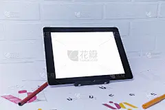 创意工作场所的平面设计师与平板电脑。为公司开发一个标志。在美术工作室办公室的纸上画素描。