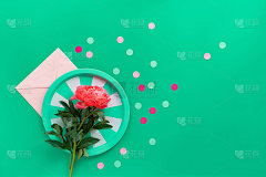 绿色条纹金属托盘与单粉红色牡丹花在纸信封上的绿色背景与文字空间。时尚休闲自然环保平铺。夏季生日或母亲