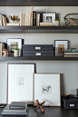 image via Decor Pad | Office vignette with espresso floating shelves, black file boxes and gallery frames.: 