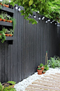 Modern garden with black fencing and white pebbles | Growing Spaces
