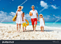 Happy beautiful family with kids walking together on tropical beach during summer vacation