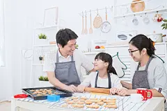 Portrait of little asian girl and her parents baking cake and cookies together in the kitchen. Happy asian family and motherâs day conceptPortrait of little asian girl and her parents baking cake and cookies together in the kitchen. Happy asian family a