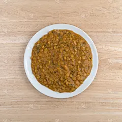 木桌上的盘子里放着菠菜和扁豆