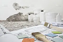 房屋改造和规划概念。笔刷和采样颜色以上的蓝图项目绘制。用于油漆和抹灰的桶和桶罐产品，以碎石为背景的正