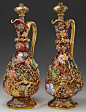 A pair of Moser decorated decanters with heavy applied grape leaves, stems, and clusters against a shaded Amberina background.