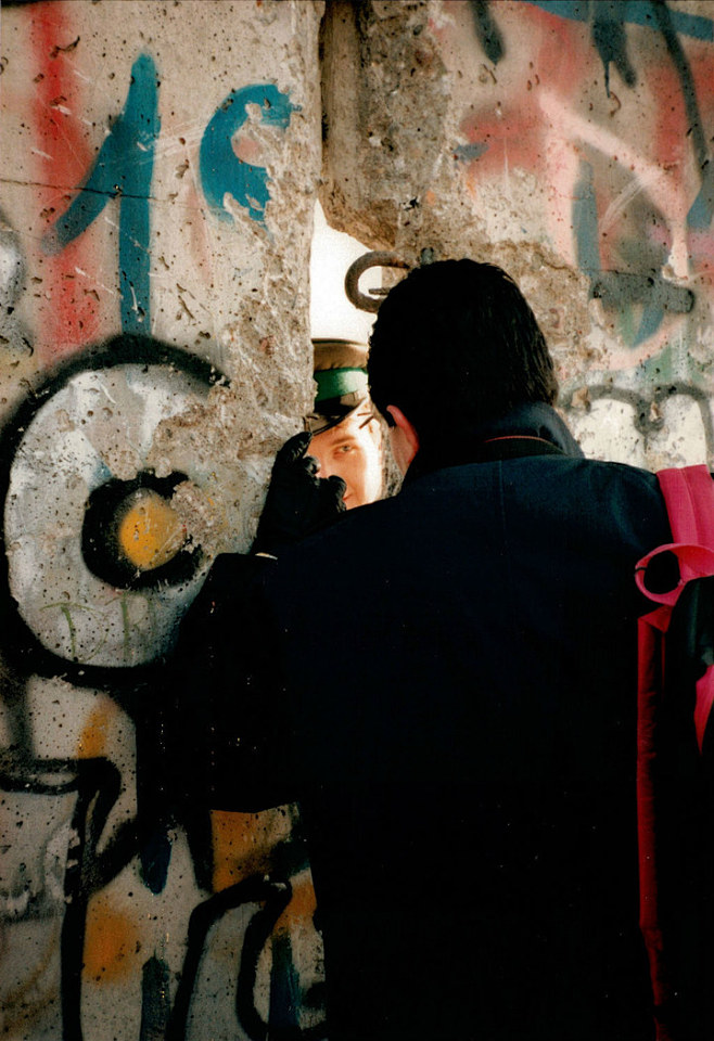 1989年，东德士兵和西德人通过柏林墙上...