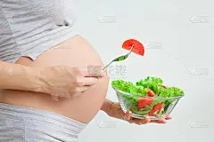 健康的营养和怀孕。孕妇的肚子和蔬菜沙拉。孕期营养。素食主义和怀孕。孕期维生素，孕期饮食
