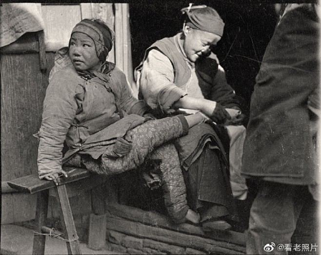 1919年，浙江石岭。一个妇女在给一个女...