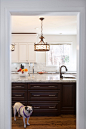 Example of a large classic u-shaped dark wood floor eat-in kitchen design in DC Metro with raised-panel cabinets, white cabinets, marble countertops, white backsplash, stone tile backsplash, stainless steel appliances and an island