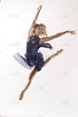 穿着蓝色裙子的芭蕾舞者，在蓝色背景下跳跃。