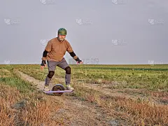 成熟的老年男性正在骑着单轮电动滑板