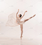 年轻优雅温柔的芭蕾舞女演员在白色的工作室背景