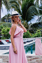 Portraif of caucasian woman in romantic elegant pink long dress on vacation at luxury rich villa hotel with amazing tropical palm trees view female in classic white hat