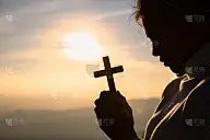 基督教年轻妇女在日出时用十字架祈祷的剪影，基督教概念背景。