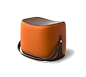 Hermès | Ottoman with strap that makes it highly portable. L21.1" x H14.1" x W13.6". Storage area covered in chocolate leather.<br />Cover in pumpkin Palomino velvet.<br /><br />Recalling the shape of a saddle, the ottoman