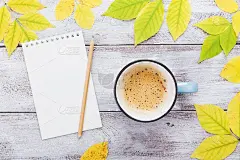 一杯咖啡，打开空笔记本和秋叶在古董木桌子上顶视图。温馨的早餐。遗愿清单。