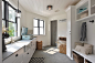 Large country galley gray floor utility room photo in Seattle with a farmhouse sink, recessed-panel cabinets, white cabinets, marble countertops, white walls and white countertops