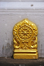 老挝琅勃拉邦一座佛教寺庙上的彩色金色建筑细节